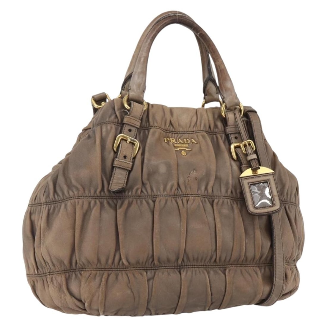 Prada Beige Leather Two Way Handbag with Name Tag and Shoulder Strap: Prada Beige Leather Two Way Handbag with Name Tag and Shoulder Strap This PRADA 2-way handbag is crafted from beige and gold leather and can be carried by hand or worn over the shoulder with the inclu