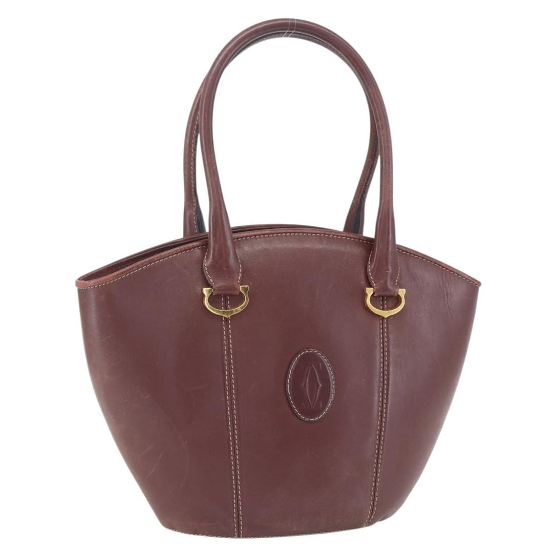 Cartier Must Line Bordeaux Leather Handbag with Gold Tone Details: Cartier Must Line Bordeaux Leather Handbag with Gold Tone Details This is a Cartier Must Line hand bag crafted from leather in a bordeaux color with gold-tone accents. The bag features a structured si