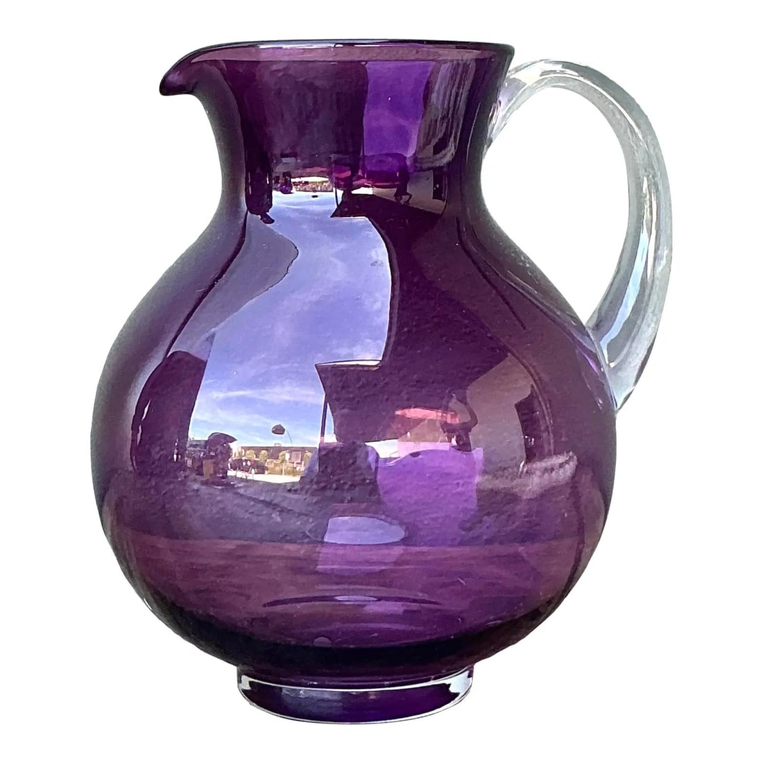 Purple Hand-Blown Glass Pitcher with Clear Handle Vintage Bulbous Design: Purple Hand-Blown Glass Pitcher with Clear Handle Vintage Bulbous Design This vintage hand-blown art glass pitcher features a vibrant amethyst purple body with a thick, clear applied handle, reflectin