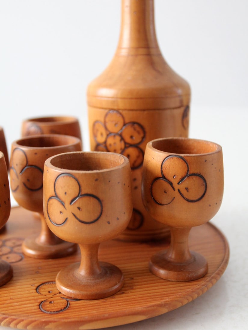 Vintage 1970 Folk Art Wooden Decanter Cup Set with Tray: Vintage 1970 Folk Art Wooden Decanter Cup Set with Tray Discover a charming vintage wooden decanter and cup set, crafted around 1970. This folk art collection showcases exquisite floral pyrography des