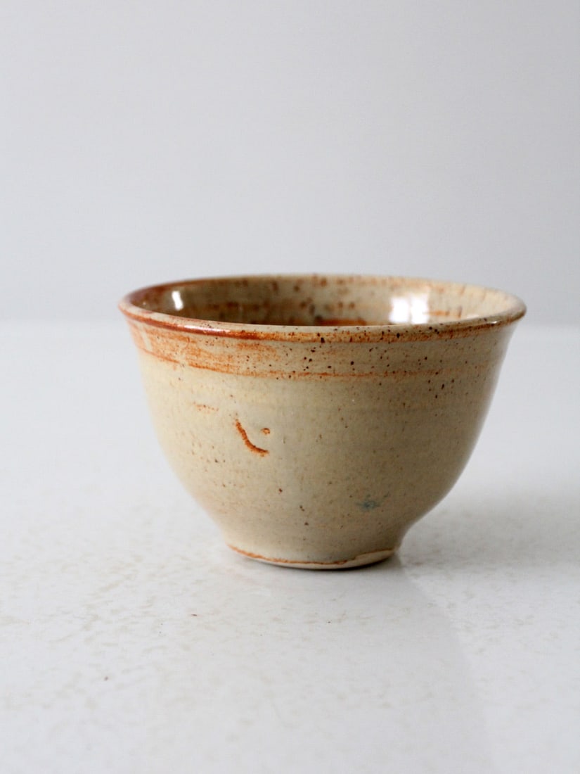 Signed Vintage Studio Pottery Bowl with Beige Glaze and Tawny Accents: Signed Vintage Studio Pottery Bowl with Beige Glaze and Tawny Accents This vintage studio pottery bowl showcases a unique handmade design, featuring a speckled beige glaze complemented by tawny accent