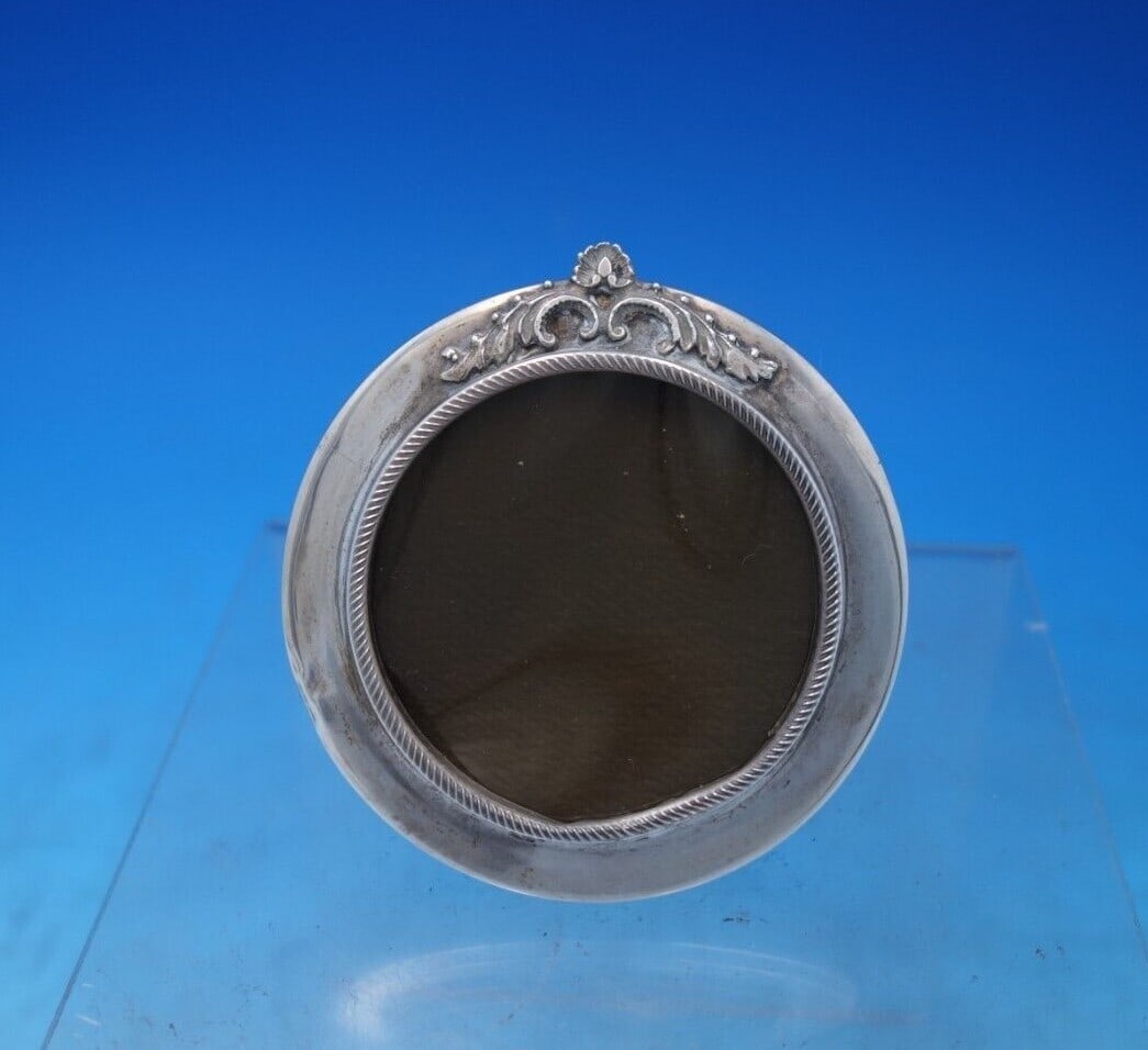 .900 Silver Round Picture Frame 3 7/8 x 2 7/8 Vintage Style: .900 Silver Round Picture Frame 3 7/8 x 2 7/8 Vintage Style Showcase your cherished memories with this exquisite .900 silver round picture frame. Measuring 3 7/8" x 2 7/8", it is designed to elegantly