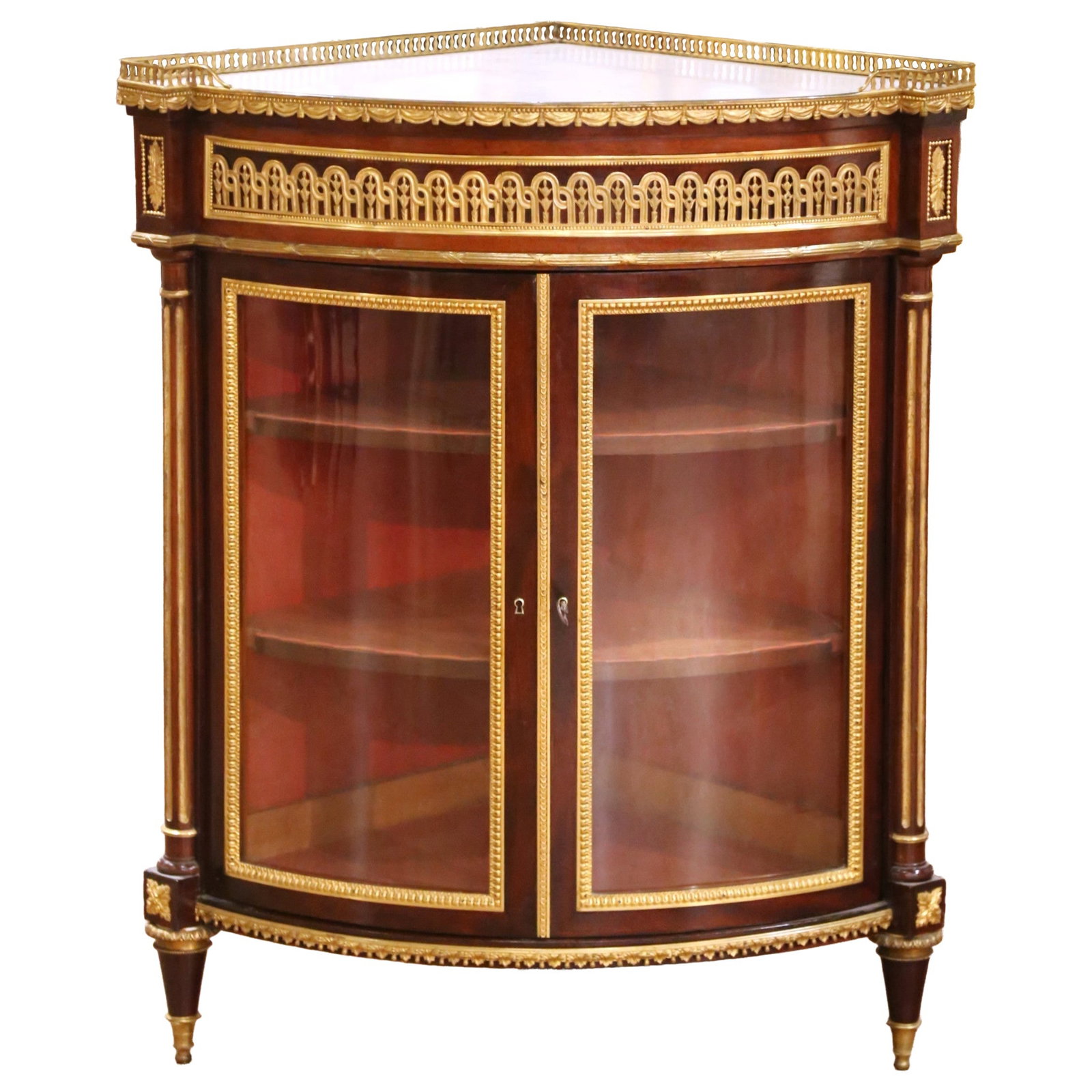 19th Century Louis XVI Mahogany Ormolu Corner Vitrine with Marble Top: 19th Century Louis XVI Mahogany Ormolu Corner Vitrine with Marble Top This exquisite late 19th-century Parisian Louis XVI style corner vitrine showcases the artistry of French cabinetry. Crafted aroun