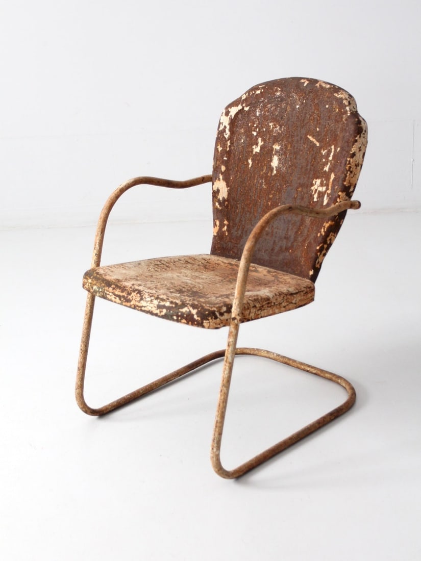 Vintage Mid-Century Shell Back Metal Patio Chair: Vintage Mid-Century Shell Back Metal Patio Chair This charming mid-century shell back patio chair features a classic metal design with a unique shell-shaped back and a sturdy "bouncer" frame. The chai