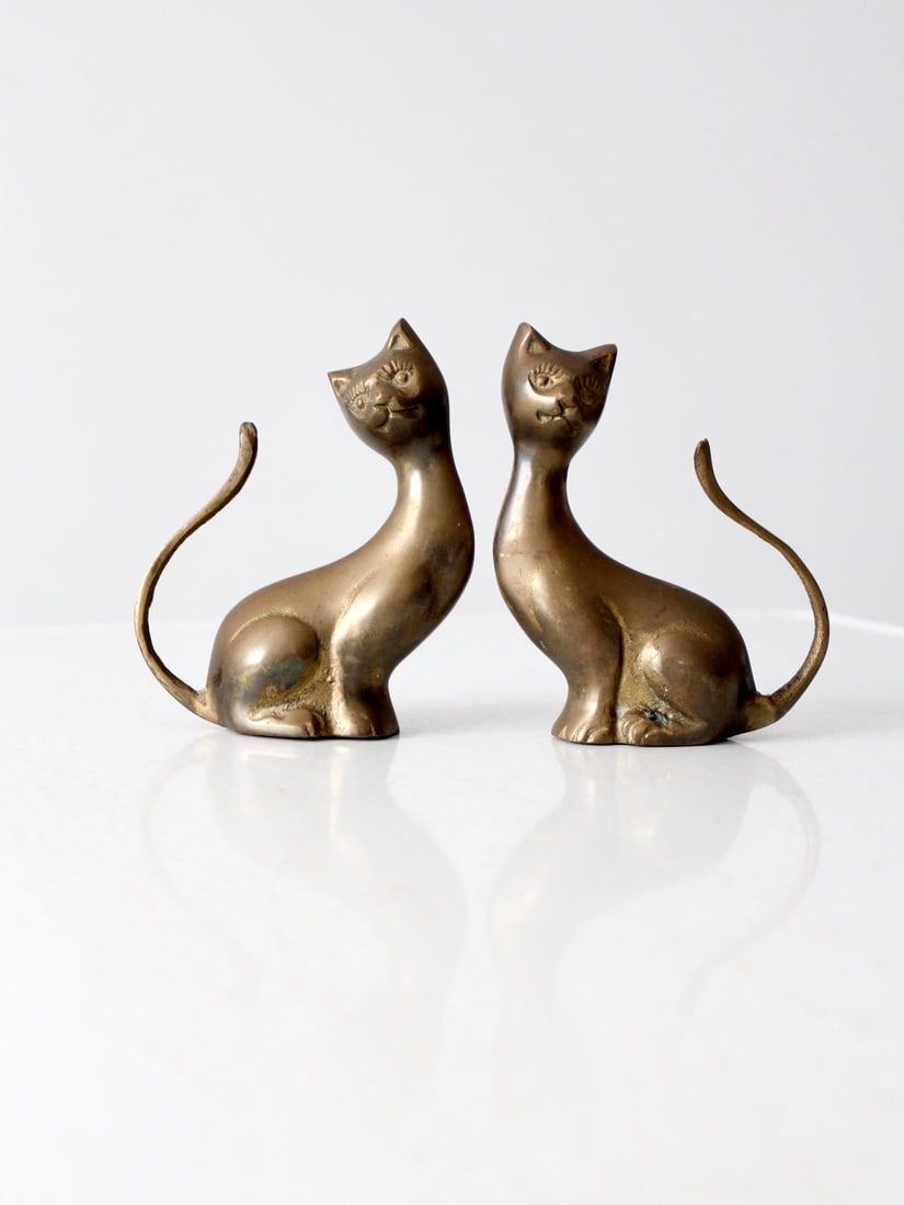 Mid-Century Brass Cat Figures Pair with Patina Accent: Mid-Century Brass Cat Figures Pair with Patina Accent This charming pair of mid-century brass cat figures showcases a stunning patina, making them a stylish and timeless addition to any decor. Their u