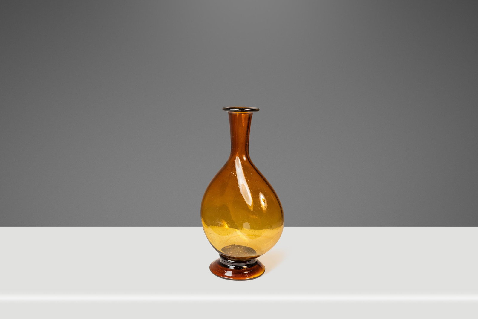 Vintage Mid-Century Modern Amber Blown Glass Bud Vase 1970s USA: Vintage Mid-Century Modern Amber Blown Glass Bud Vase 1970s USA This stunning Mid-Century Modern abstract bud vase epitomizes unique craftsmanship with its brilliant amber blown glass. Hand-made in th