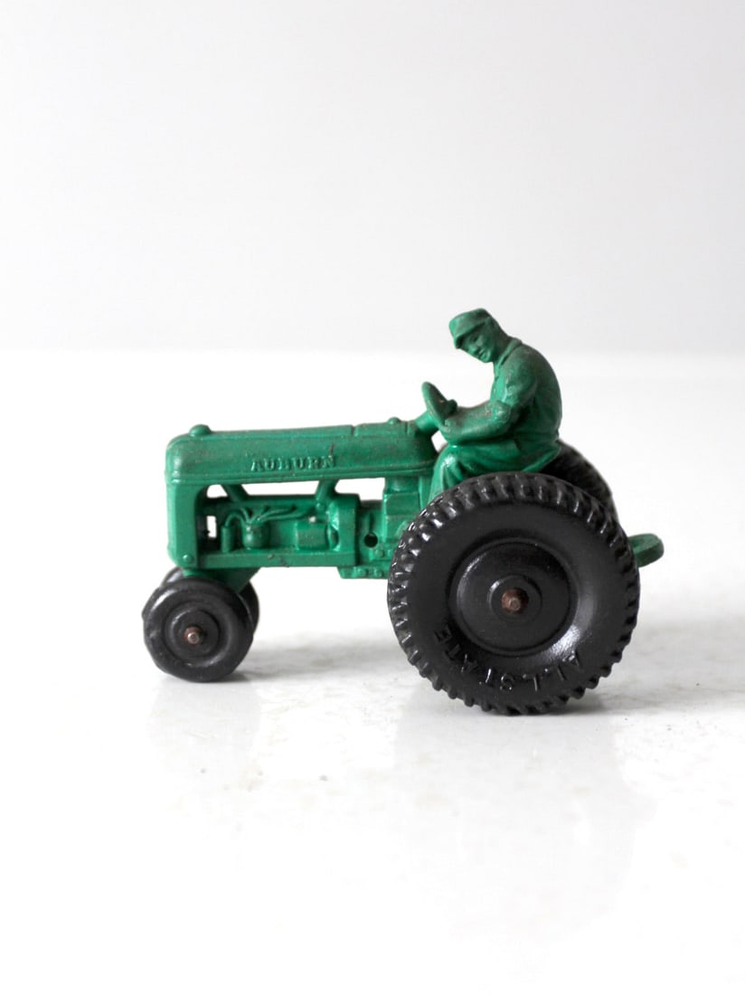 1950s Vintage Auburn Rubber Toy Tractor Green Hard Rubber: 1950s Vintage Auburn Rubber Toy Tractor Green Hard Rubber Presenting a charming vintage toy tractor from the Auburn Rubber Company, dating back to the 1950s. This delightful piece is crafted from gree