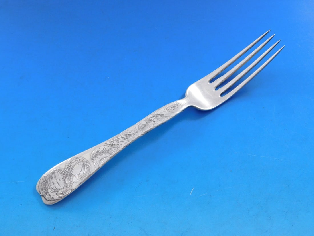 Tiffany Sterling Silver Fork Lap Over Edge Apple Motif 7 1/4": Tiffany Sterling Silver Fork Lap Over Edge Apple Motif 7 1/4" This exquisite Lap Over Edge fork by Tiffany & Co. showcases a beautiful acid-etched apple motif, a hallmark of the renowned brand's craft