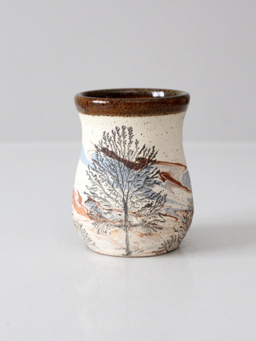 Unique Vintage Studio Pottery Mug with Hand-Painted Trees: Unique Vintage Studio Pottery Mug with Hand-Painted Trees This vintage studio pottery mug showcases a unique earthy swirl glaze, adorned with hand-painted trees that reflect a nature-inspired theme. A