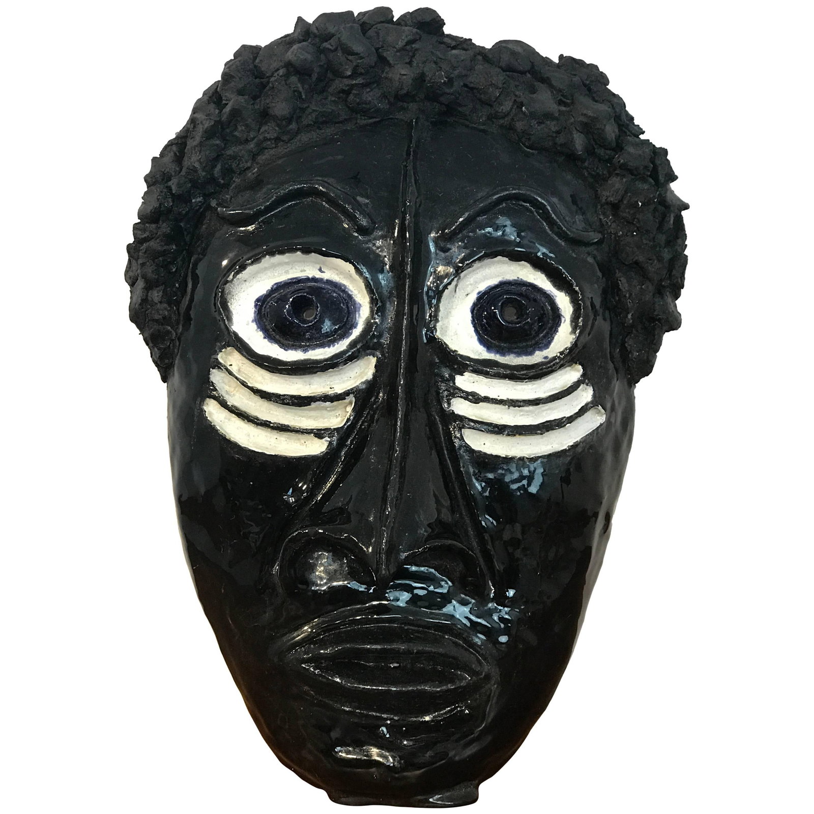 Pottery African Mask Modernist Wall Art in the Style of Wiener Werkstatte: Pottery African Mask Modernist Wall Art in the Style of Wiener Werkstatte This mid-century pottery mask is crafted in the style of Wiener Werkstatte and features an exotic African motif. The piece is