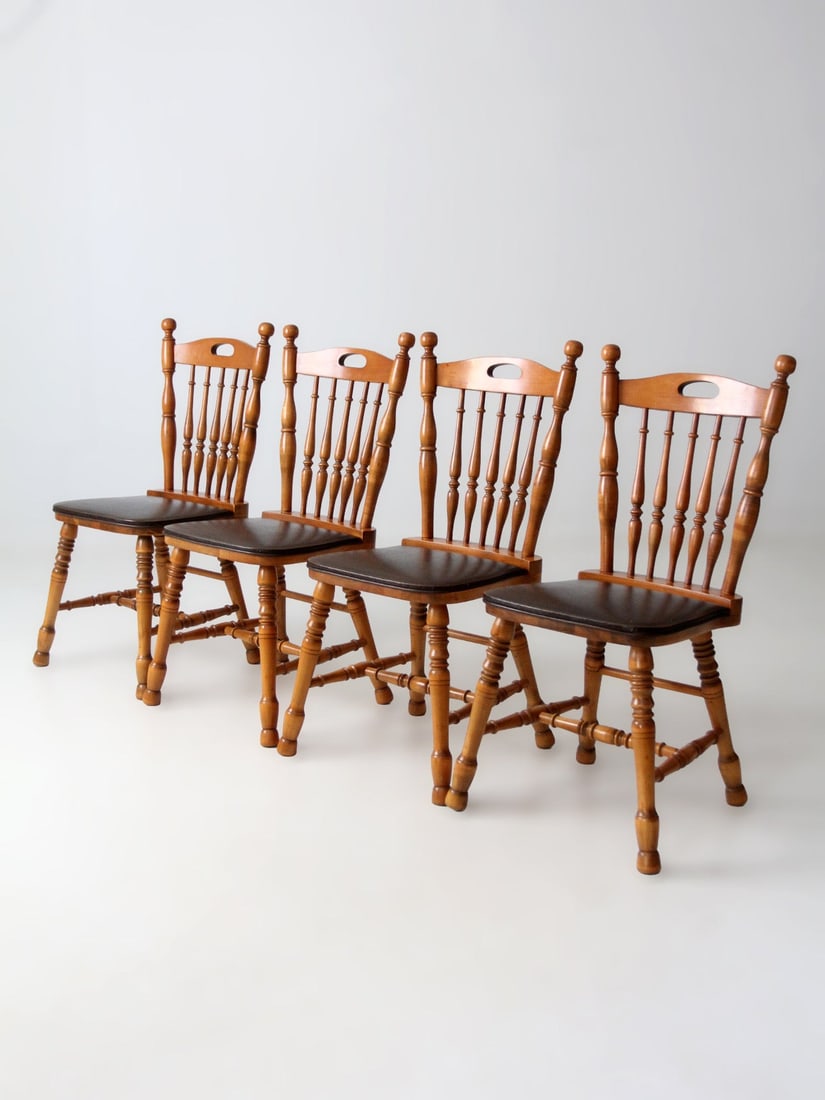 Set of Four Vintage Wood Spindle Back Dining Chairs with Turned Legs: Set of Four Vintage Wood Spindle Back Dining Chairs with Turned Legs This set includes four vintage spindle back dining chairs crafted with turned legs, classic stretchers, and sculpted wood frames fi