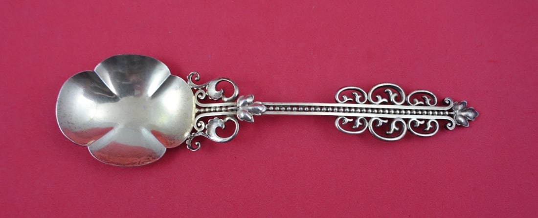 Sterling Silver Preserve Spoon With Maple Leaf Finial By Shiebler 7 1/4": Sterling Silver Preserve Spoon With Maple Leaf Finial By Shiebler 7 1/4" This is a sterling silver preserve spoon by Shiebler, featuring a vermeil finish and a distinctive maple leaf finial. The spoon