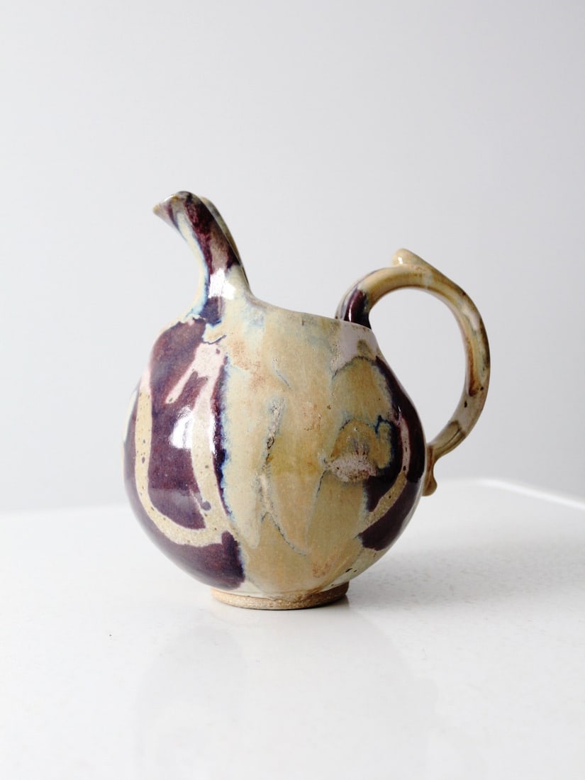 Handmade Sculptural Studio Pottery Pitcher With Layered Glaze 9 Inch: Handmade Sculptural Studio Pottery Pitcher With Layered Glaze 9 Inch This vintage handmade studio pottery pitcher showcases a rounded sculptural form with a softly pulled spout and a curved loop handl