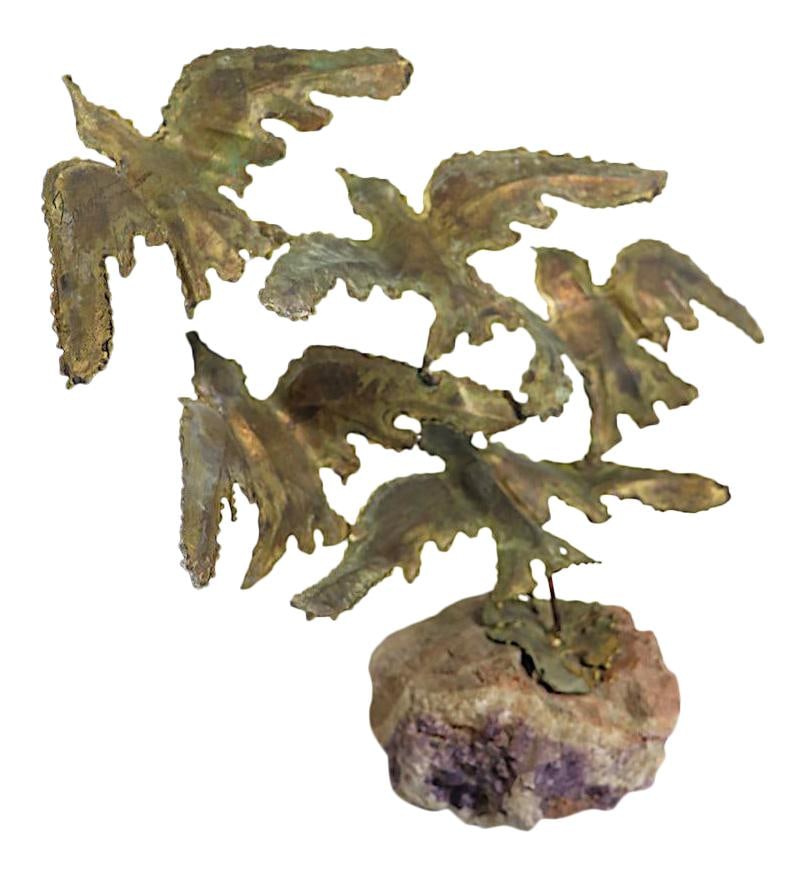 Brutalist Torch Cut Brass Bird Sculpture on Quartz Base: Brutalist Torch Cut Brass Bird Sculpture on Quartz Base This striking Brutalist sculpture features a dynamic representation of a flock of birds in flight, crafted from torch cut brass and elegantly mo