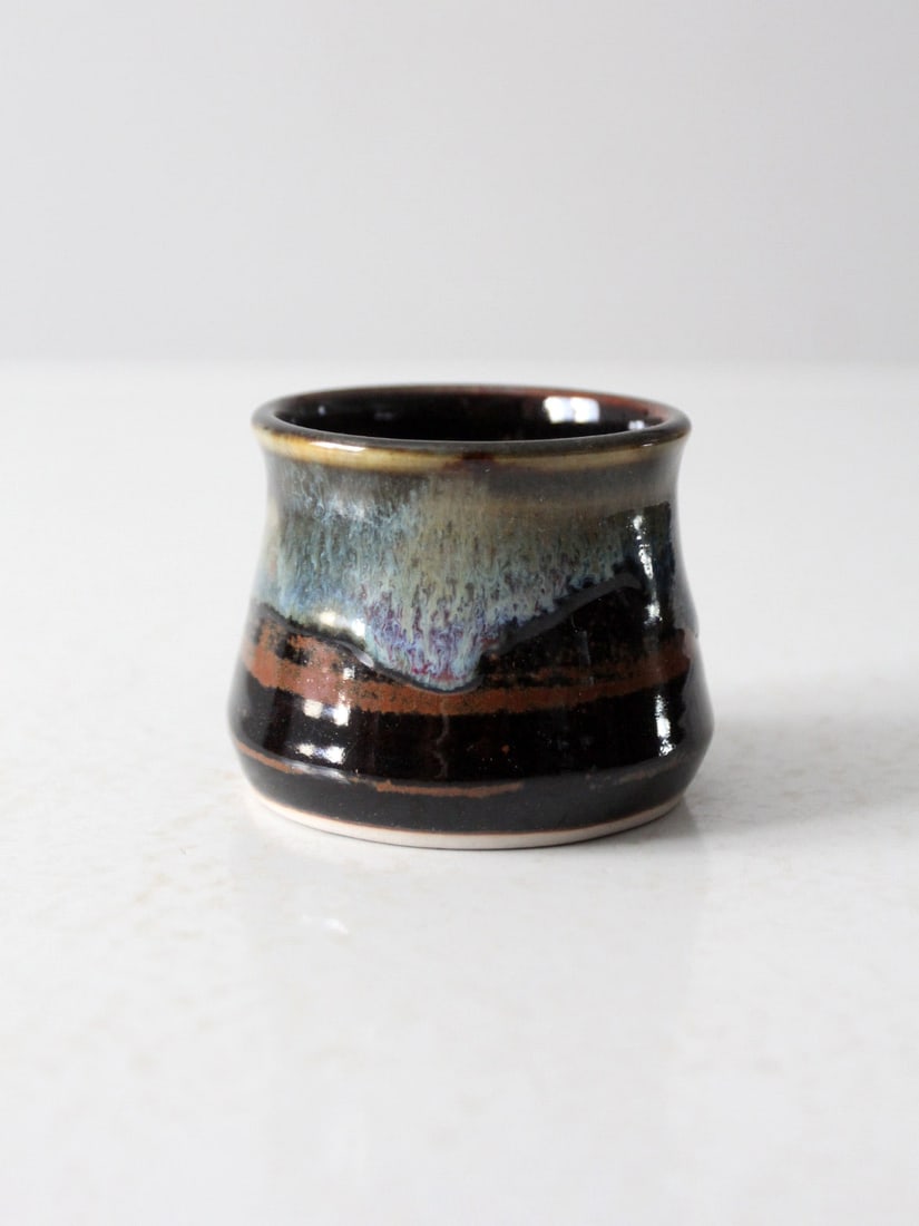 Vintage Handmade Studio Pottery Vase with Earthy Glaze: Vintage Handmade Studio Pottery Vase with Earthy Glaze This vintage handmade studio pottery vase showcases a unique organic shape complemented by a rich, earthy glaze. It is perfect for displaying sma