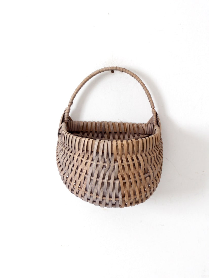 Vintage Ribbed Wicker Wall Basket with Bentwood Handle: Vintage Ribbed Wicker Wall Basket with Bentwood Handle This vintage wicker wall basket features a beautifully ribbed woven design in natural and gray tones. With its bulbous body and flat back, it han