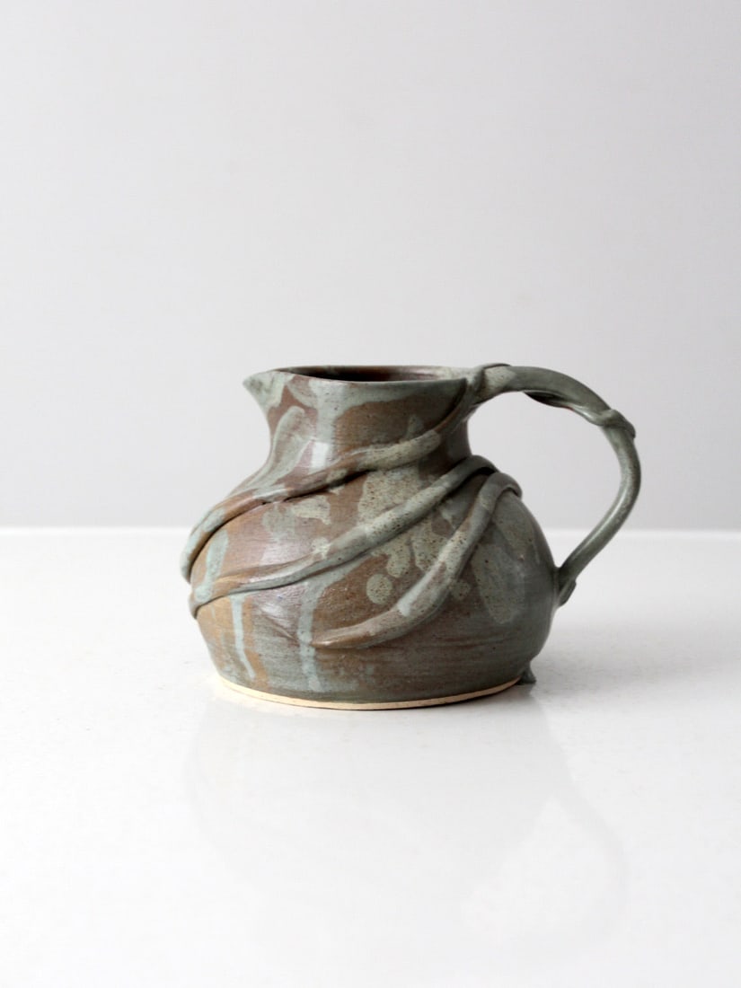 Handmade Vintage Studio Pottery Ewer with Vine Design: Handmade Vintage Studio Pottery Ewer with Vine Design This vintage studio pottery pitcher showcases a unique handmade design, featuring a raised ceramic vine motif that elegantly wraps around its body