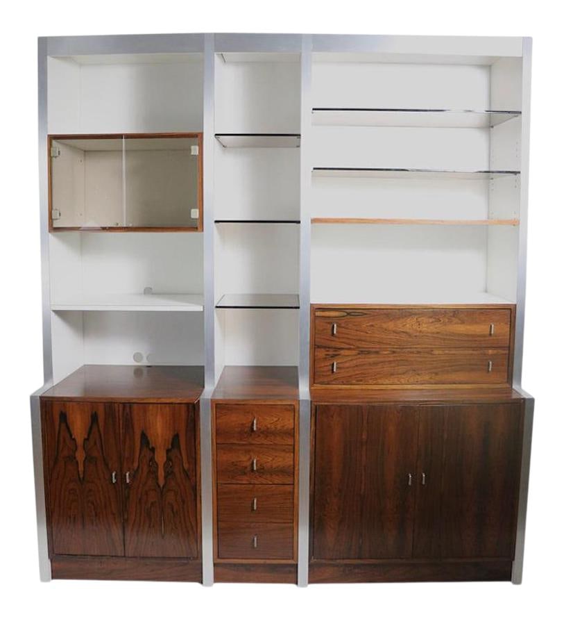 1970s Rosewood and Glass Wall Unit by Baughman for John Stuart: 1970s Rosewood and Glass Wall Unit by Baughman for John Stuart This stunning wall unit features elegant rosewood cabinets complemented by white Formica surfaces, brushed metal trim, and tinted glass s