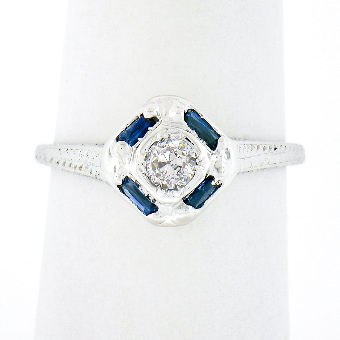 Antique Art Deco 18K White Gold Diamond Sapphire Engagement Ring: Antique Art Deco 18K White Gold Diamond Sapphire Engagement Ring This exquisite antique engagement ring showcases the elegance of the Art Deco period, crafted from solid 18K white gold. At its center,