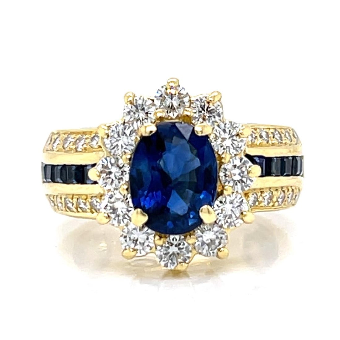 18K Yellow Gold Sapphire Diamond Ring 2.10 Ct Sapphire 1.50 Ct Diamonds: 18K Yellow Gold Sapphire Diamond Ring 2.10 Ct Sapphire 1.50 Ct Diamonds This exquisite 18K Yellow Gold ring features a stunning central sapphire weighing approximately 2.10 Ct, complemented by 10 addi
