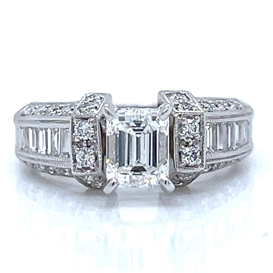 14K White Gold 1.03 Ct Emerald-Cut Diamond Ring with Baguettes: 14K White Gold 1.03 Ct Emerald-Cut Diamond Ring with Baguettes This stunning 14K White Gold ring features a breathtaking 1.03 Ct. Emerald-cut diamond at its center, boasting an E color and VS1 clarity