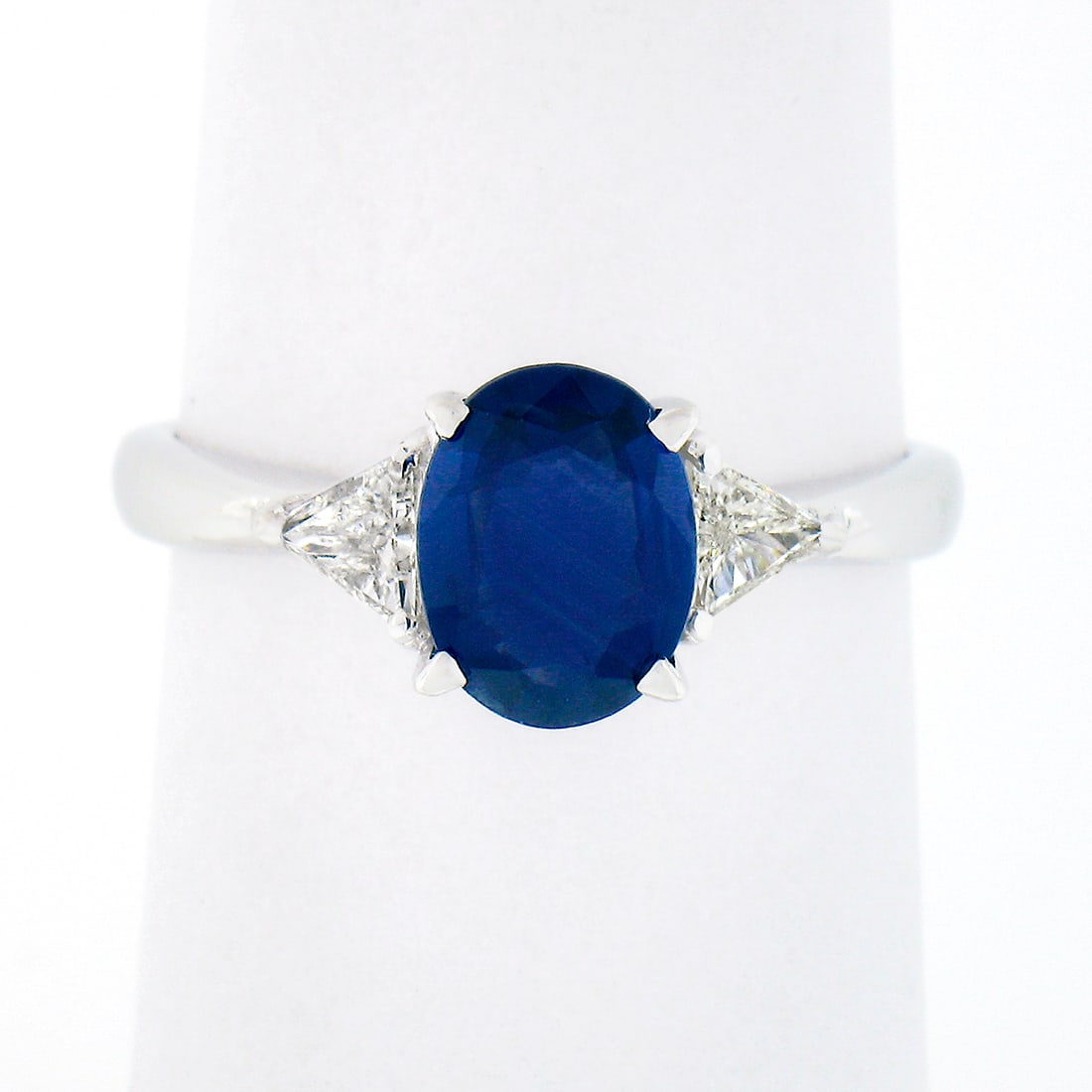 18K White Gold GIA Certified 2.21ct Oval Sapphire & Trillion Diamond Three Stone Ring: 18K White Gold GIA Certified 2.21ct Oval Sapphire & Trillion Diamond Three Stone Ring This exquisite three-stone ring showcases a stunning GIA certified oval sapphire, weighing approximately 1.65ct, e