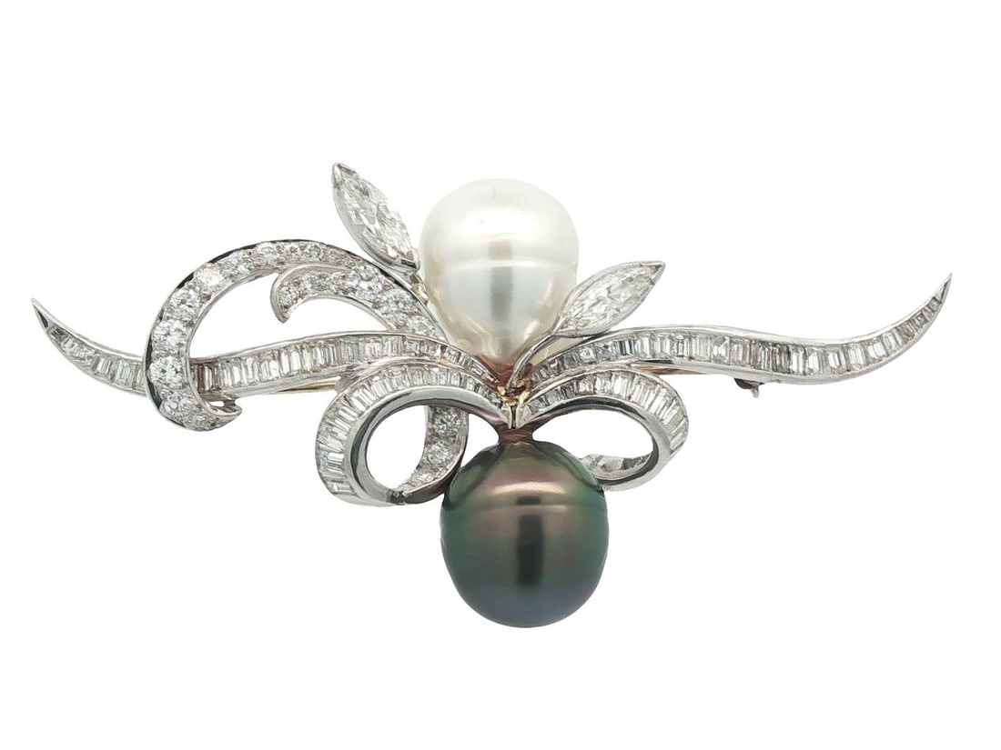 Vintage Platinum Floral Brooch with Baroque Pearls and Diamonds: Vintage Platinum Floral Brooch with Baroque Pearls and Diamonds This exquisite vintage brooch showcases a stunning combination of Baroque pearls and diamonds, elegantly designed in a floral ribbon mot