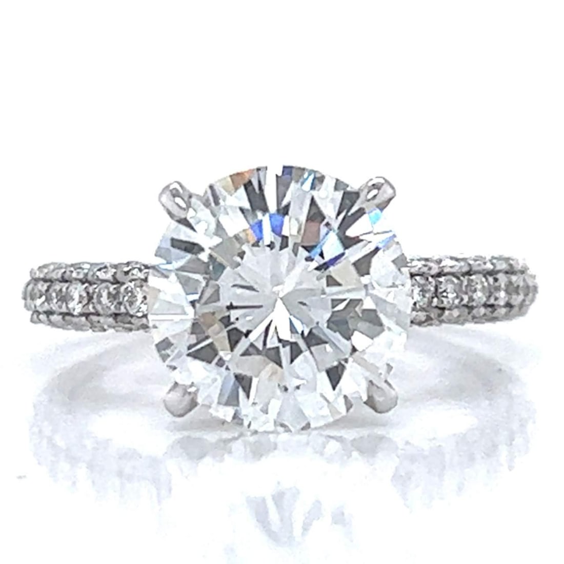 18K White Gold GIA Certified 3.02 Ct Diamond Ring E VS1: 18K White Gold GIA Certified 3.02 Ct Diamond Ring E VS1 This exquisite 18K White Gold Diamond Ring features a stunning GIA Certified 3.02 Ct. round diamond at its center, exhibiting E color and VS1 cl