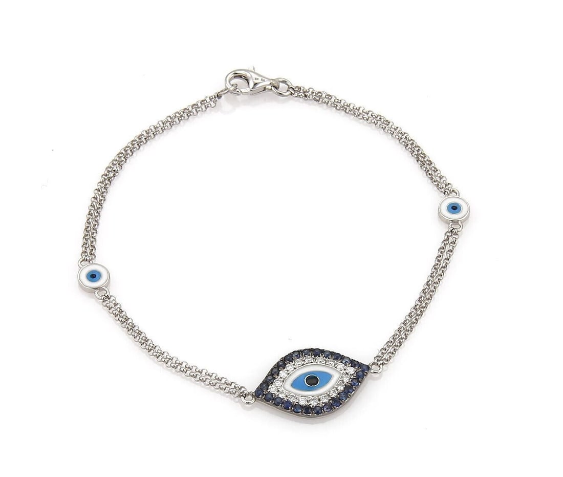 Evil Eye Charm Bracelet in 18k White Gold with Diamond Sapphire Enamel Double Chain: Evil Eye Charm Bracelet in 18k White Gold with Diamond Sapphire Enamel Double Chain This vintage charm bracelet features an evil eye design adorned with diamonds, sapphires, and enamel, all set in 18k