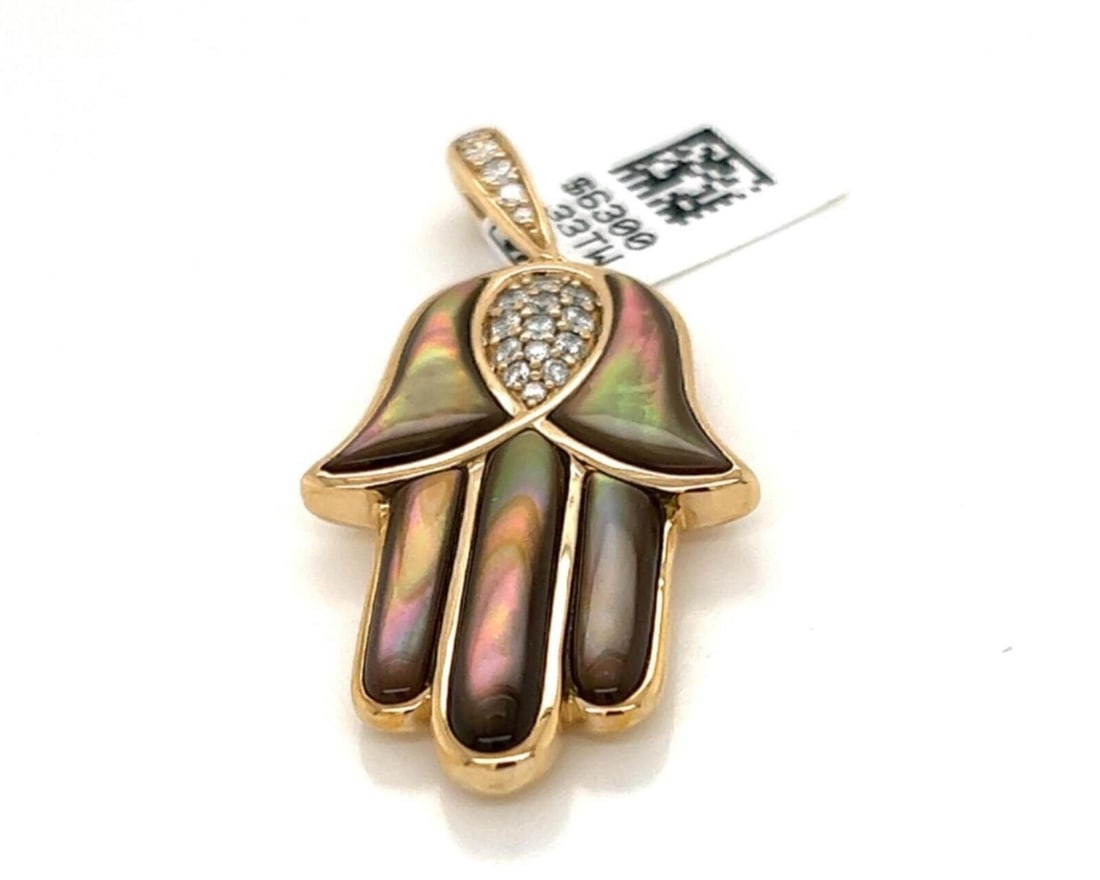 Large 14k Gold Mother of Pearl Diamond Hand of God Pendant by Kabana: Large 14k Gold Mother of Pearl Diamond Hand of God Pendant by Kabana This Kabana pendant features a large Hand of God charm crafted in 14k yellow gold. The piece showcases a mother of pearl inlay acce
