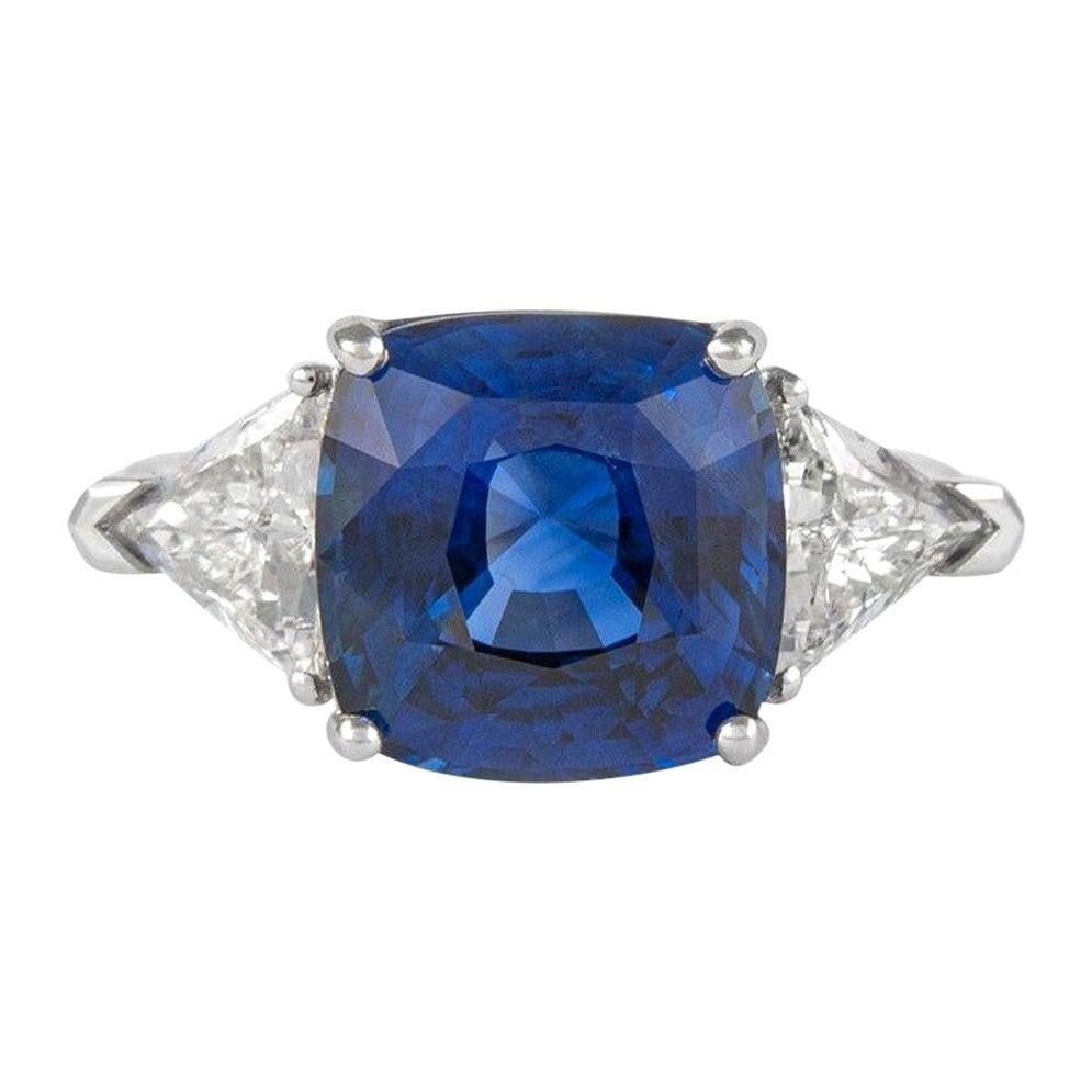 7.11ct GIA Sapphire Diamond Three-Stone Ring 18k White Gold: 7.11ct GIA Sapphire Diamond Three-Stone Ring 18k White Gold This stunning three-stone ring features a GIA-certified 7.11ct cushion-cut blue sapphire, beautifully complemented by a pair of trilliant di