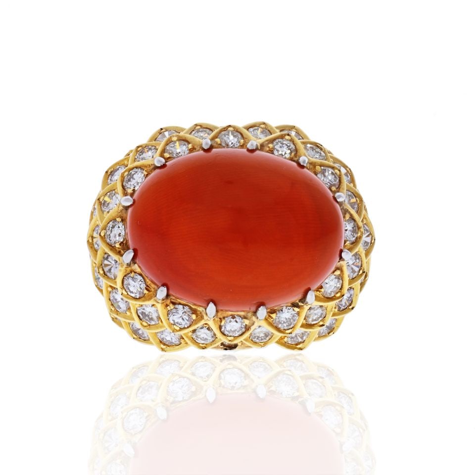 David Webb 1970s Platinum 18K Gold Coral Diamond Ring: David Webb 1970s Platinum 18K Gold Coral Diamond Ring This exquisite David Webb ring, crafted in the 1970s, showcases a stunning oval cabochon coral at its center, elegantly framed in an 18K yellow go