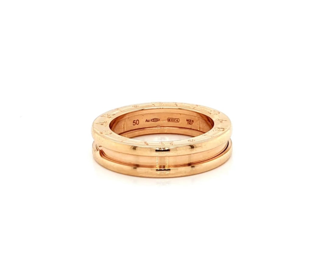 B.zero1 One-Band 18k Rose Gold Ring Size 5 With Certificate by Bvlgari: B.zero1 One-Band 18k Rose Gold Ring Size 5 With Certificate by Bvlgari This Bvlgari B.zero1 One-Band Ring showcases a sleek, minimalist design crafted in 18k rose gold. Featuring the iconic single-ban