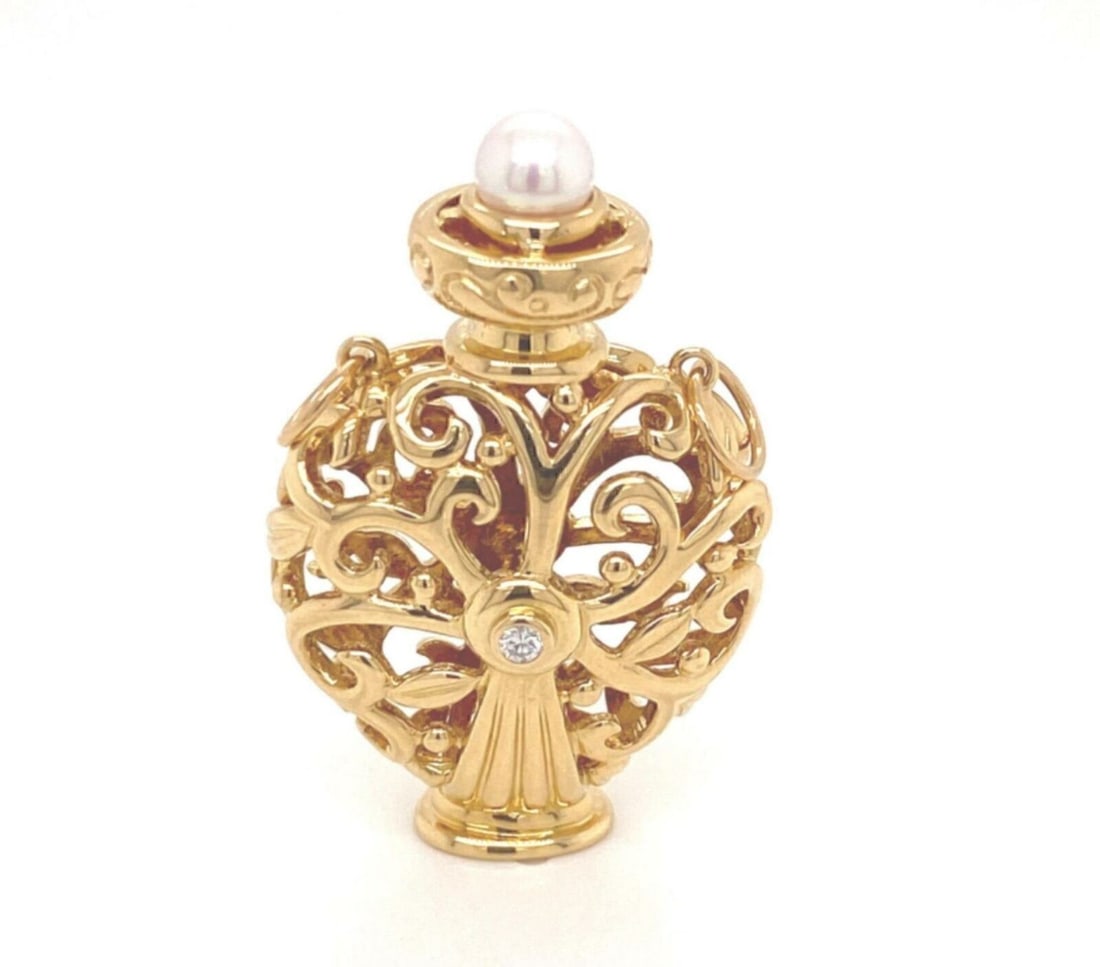 Vintage 18k Gold Akoya Pearl and Diamond Bottle Pendant by Mikimoto: Vintage 18k Gold Akoya Pearl and Diamond Bottle Pendant by Mikimoto This vintage Mikimoto charm pendant features an open bottle design crafted in 18k yellow gold. The piece is adorned with a 5mm Akoya