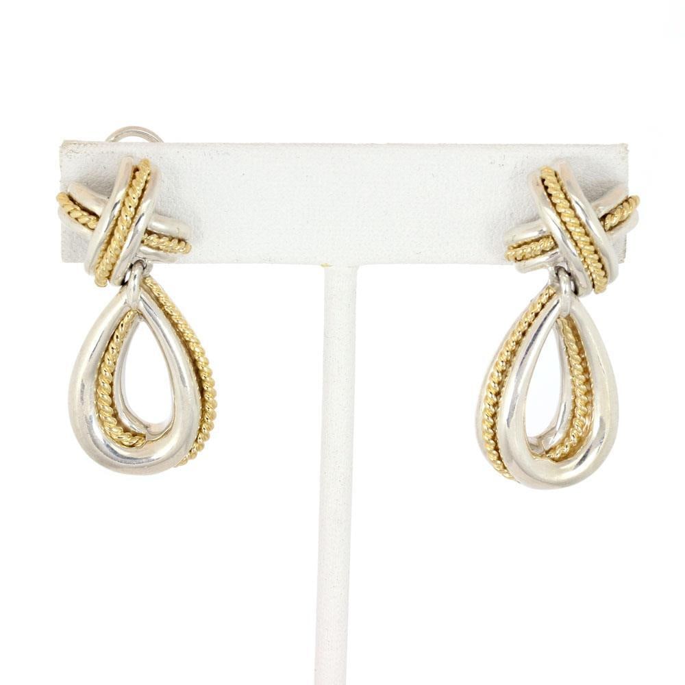 Tiffany & Co. 18k Yellow Gold Sterling Silver X Crossover Loop Earrings: Tiffany & Co. 18k Yellow Gold Sterling Silver X Crossover Loop Earrings Elevate your style with this exquisite pair of earrings from Tiffany & Co. Crafted from a blend of sterling silver and 18k yello