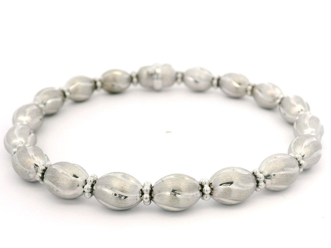 Italian 14k White Gold 7 Inch Brushed Oval Bead Link Bracelet: Italian 14k White Gold 7 Inch Brushed Oval Bead Link Bracelet This exquisite Italian bracelet is crafted from solid 14k white gold, featuring a beautiful brushed finish complemented by polished cut ov