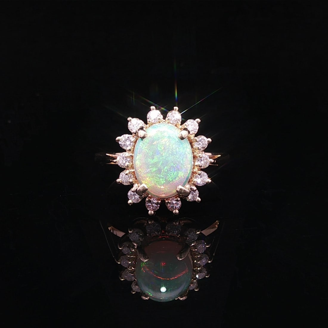 14k Yellow Gold Opal and Diamond Floral Cluster Cocktail Ring: 14k Yellow Gold Opal and Diamond Floral Cluster Cocktail Ring This cocktail ring features a natural oval cabochon opal with a white base and striking green and orange play of colors, set in solid 13-1