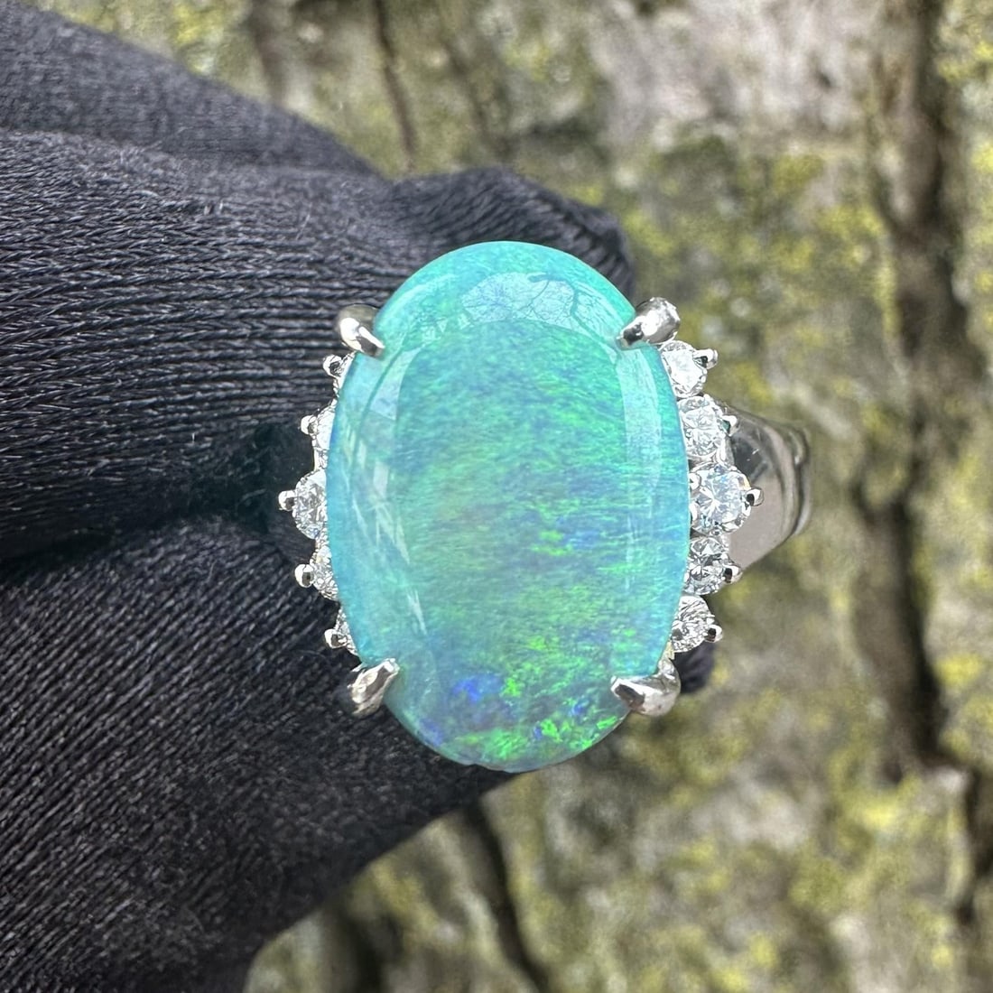 Platinum Ring with Natural Oval Opal and Round Diamond Accents 3.98ctw: Platinum Ring with Natural Oval Opal and Round Diamond Accents 3.98ctw This platinum cocktail ring features a natural genuine opal in an oval cabochon cut, prong set, and displaying a vibrant play of