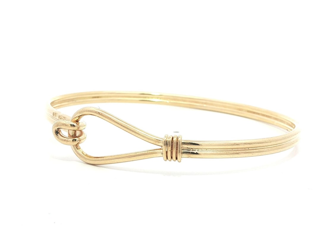 18k Yellow Gold Gucci Stirrup Knot Design Bangle Bracelet: 18k Yellow Gold Gucci Stirrup Knot Design Bangle Bracelet This vintage Gucci bangle bracelet is crafted from solid 18k yellow gold and features a distinctive stirrup knot hook design. The bracelet is