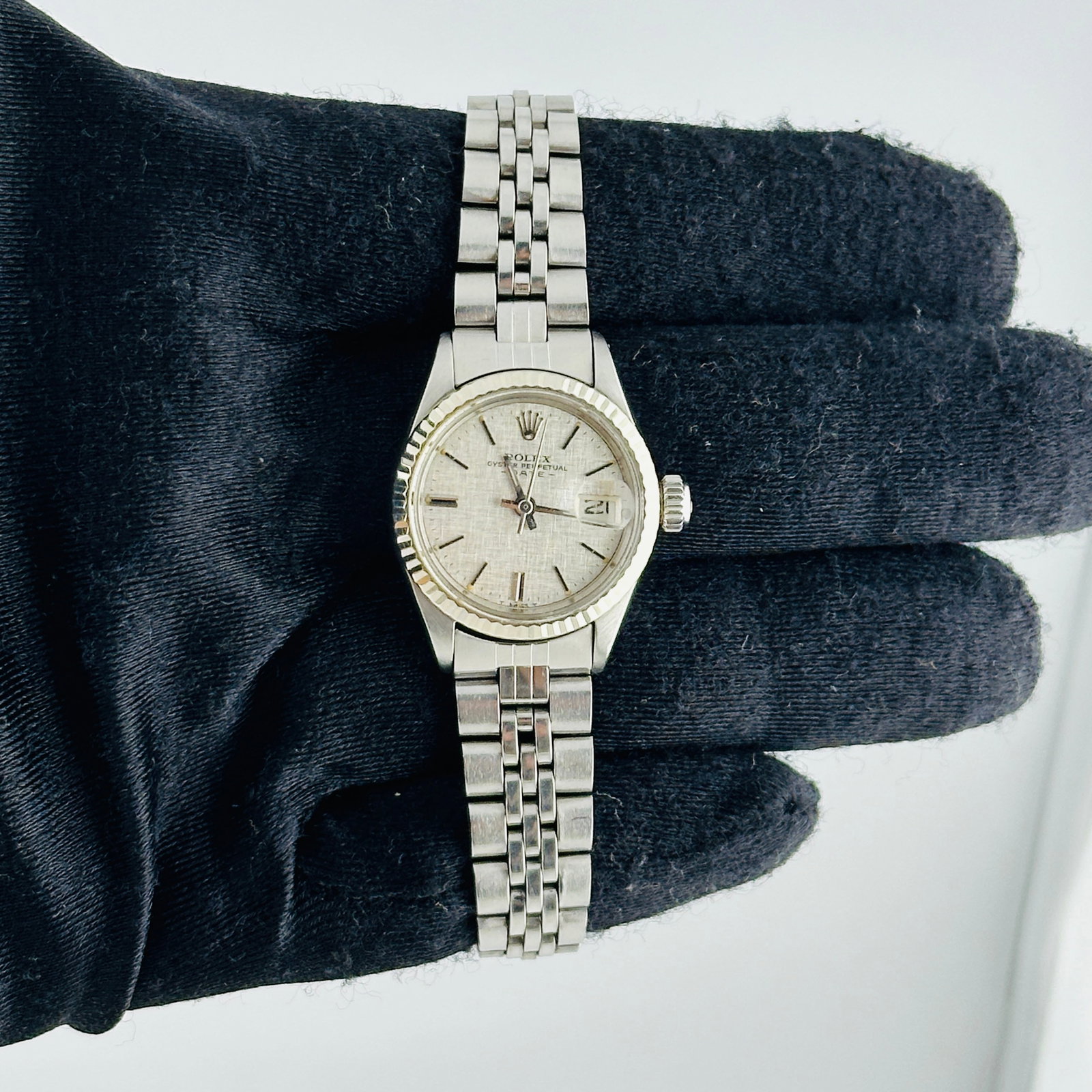 Ladies Rolex 6917 Oyster Perpetual Date Silver Linen Dial Folded Jubilee: Ladies Rolex 6917 Oyster Perpetual Date Silver Linen Dial Folded Jubilee This ladies' Rolex Oyster Perpetual Date watch features a distinctive silver linen dial and a fluted bezel. The timepiece is co