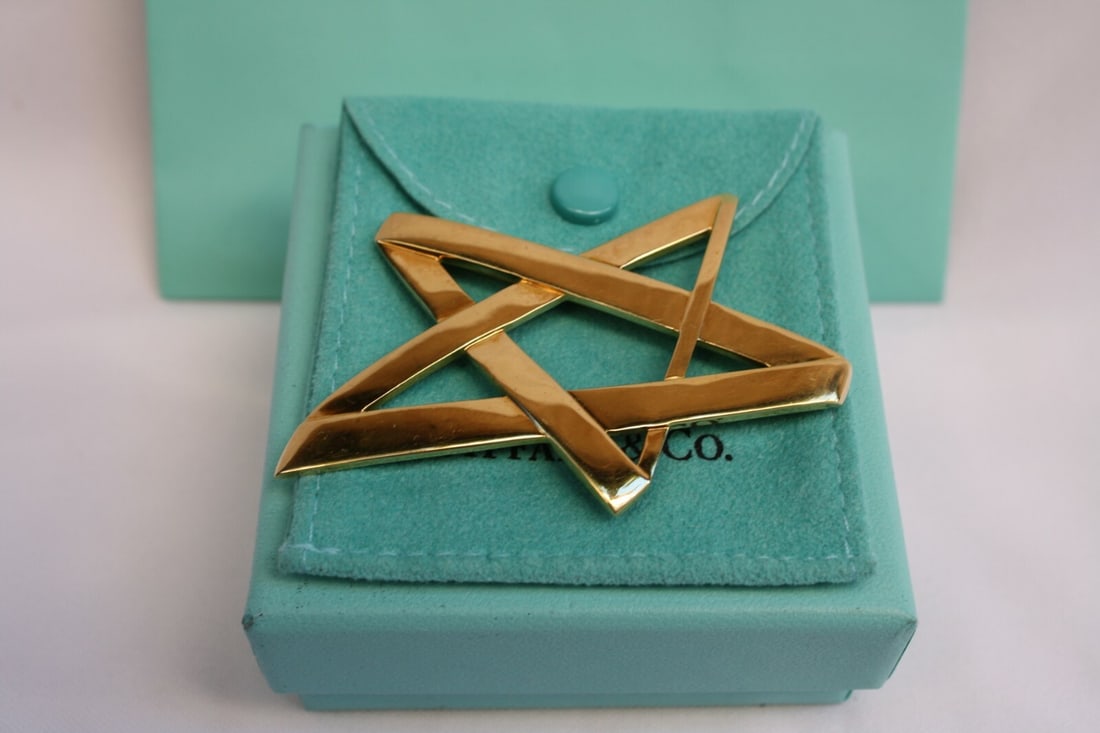 Tiffany & Co 18K Yellow Gold Paloma Picasso Brooch with Box: Tiffany & Co 18K Yellow Gold Paloma Picasso Brooch with Box This exquisite brooch from Tiffany & Co. showcases the artistry of Paloma Picasso in a stunning design crafted from 18K yellow gold. The pie