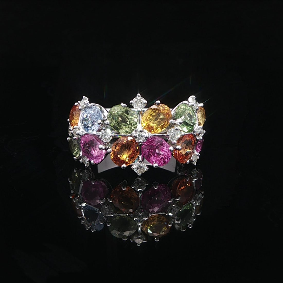 White Gold Oval Sapphire and Diamond Band Ring with Multicolor Stones: White Gold Oval Sapphire and Diamond Band Ring with Multicolor Stones This wide band ring features an array of 12 natural oval-cut sapphires in vibrant multi-color hues, including green, pink, orange,