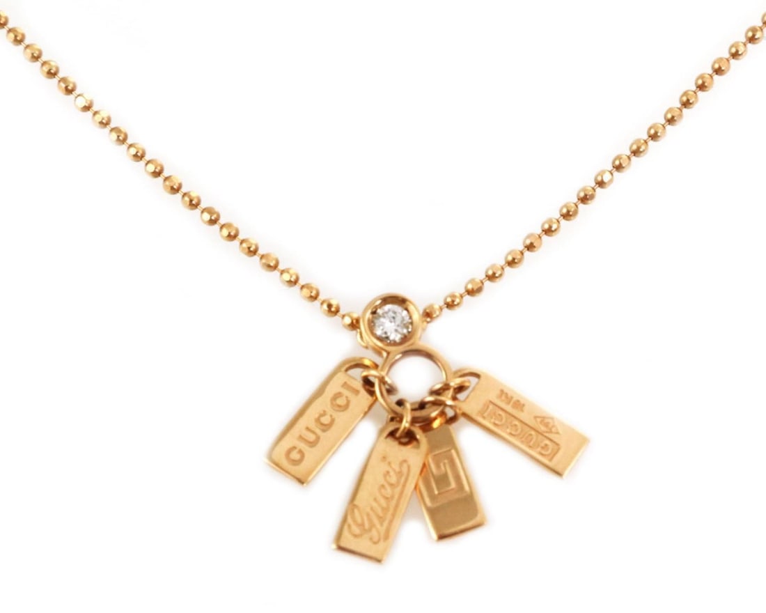 Gucci 18k Rose Gold Diamond Pendant Necklace with Four Logo Tag Charms: Gucci 18k Rose Gold Diamond Pendant Necklace with Four Logo Tag Charms This pendant necklace features a 4 logo tag design crafted in 18k rose gold and adorned with diamonds. The piece is signed by Guc