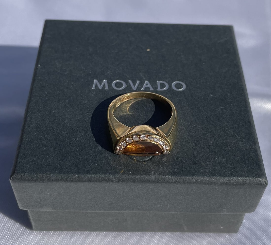 Movado 18K Yellow Gold Diamond Citrine Ring with Box: Movado 18K Yellow Gold Diamond Citrine Ring with Box This exquisite Movado ring features a stunning design crafted from 18K yellow gold, showcasing a beautiful citrine stone and accented with GVS diam