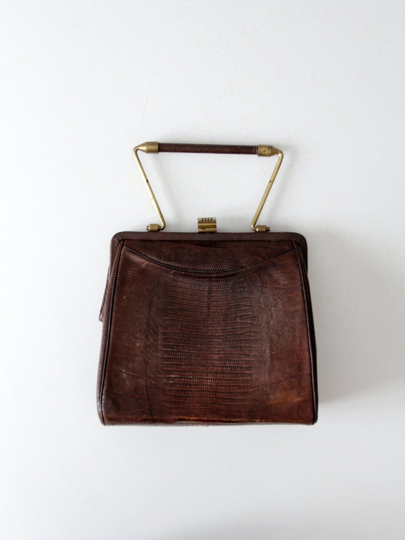 Vintage Reptile Embossed Leather Handbag with Gold Tone Handle: Vintage Reptile Embossed Leather Handbag with Gold Tone Handle This vintage reptile embossed leather framed bag embodies classic elegance and style. It features a single gold toned handle and a secure
