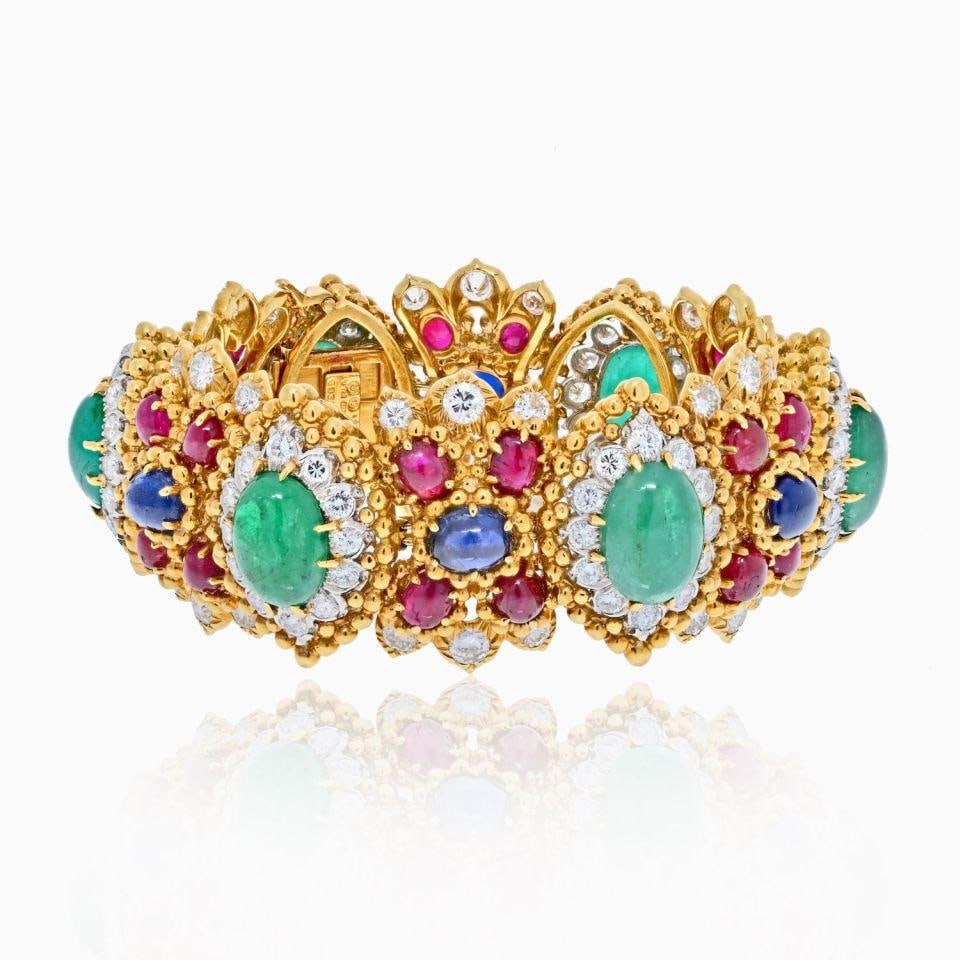 David Webb 18K Yellow Gold Emerald Ruby Diamond Cuff Bracelet: David Webb 18K Yellow Gold Emerald Ruby Diamond Cuff Bracelet This exquisite bracelet by David Webb features a luxurious design crafted from 18K yellow gold. The piece showcases a stunning arrangement