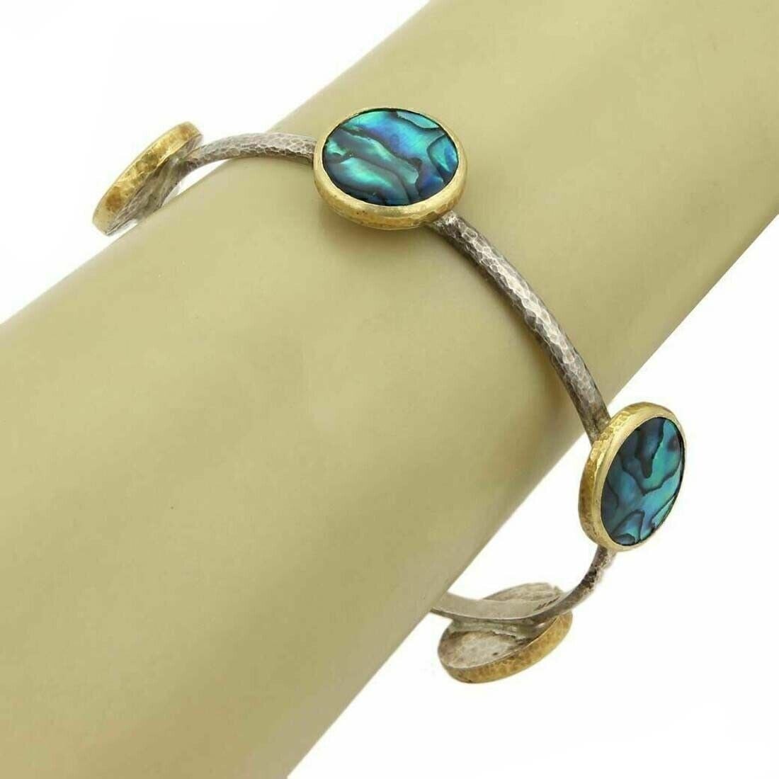 Five Station Paua Shell Bangle in 24k Gold and Sterling Silver by Gurhan: Five Station Paua Shell Bangle in 24k Gold and Sterling Silver by Gurhan This Gurhan Surf bangle features five round stations adorned with vibrant paua shell, set in a combination of sterling silver a