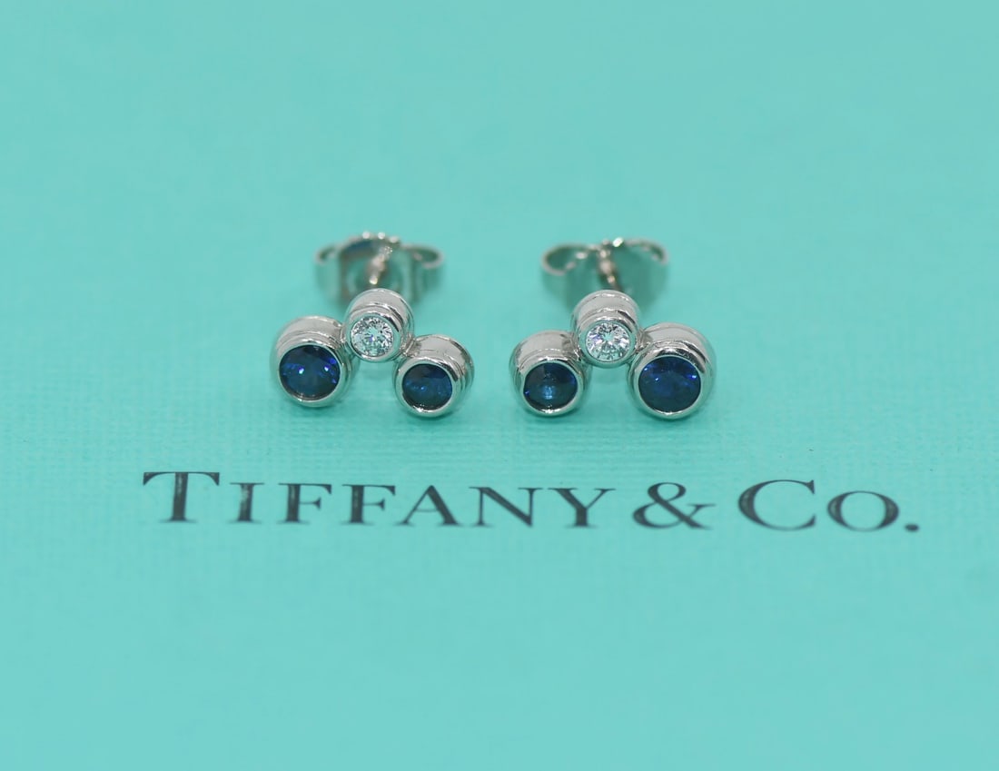 Diamond and Sapphire Stud Earrings in Platinum by Tiffany & Co: Diamond and Sapphire Stud Earrings in Platinum by Tiffany & Co These Tiffany & Co. stud earrings feature a sophisticated combination of diamonds and sapphires set in platinum. Crafted with a metal pur