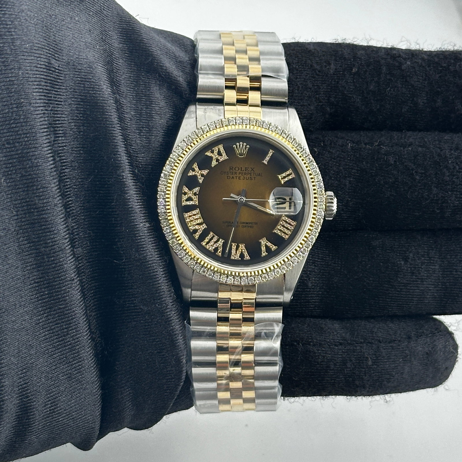 Datejust Ref 1601 Brown Black Roman Dial with Aftermarket Jubilee Bracelet: Datejust Ref 1601 Brown Black Roman Dial with Aftermarket Jubilee Bracelet This Rolex Datejust features a distinctive brown and black Roman numeral dial, complemented by a prong plated diamond bezel.