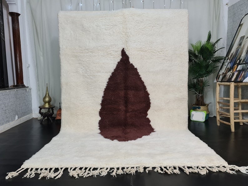 Authentic Handmade Moroccan Berber Wool Rug 9.84 x 6.56 ft: Authentic Handmade Moroccan Berber Wool Rug 9.84 x 6.56 ft Enhance your living space with this authentic White Soft Handmade Moroccan Berber Wool Rug. Featuring a beautiful brown design at its center,